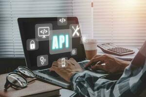 api - solicitud programación interfaz, hombre utilizando ordenador portátil computadora con toque pantalla interfaz y Seleccione api icono, software desarrollo herramienta, moderno tecnología, Internet y redes. foto