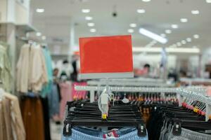 selective focus to blank red board for women's and men's clothing discount template in mall. soft focus photo