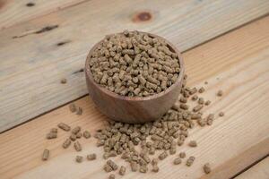 selective focus on brown chicken pellets on a wooden bowl, pellets are chicken feed made from corn and vegetables mixed with water photo