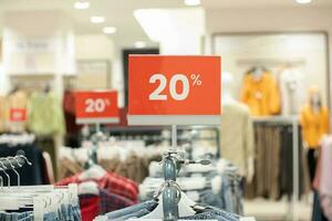 selective focus to red discount board with 20 percent writing. for discount templates for women's and men's clothing at the mall. soft focus photo