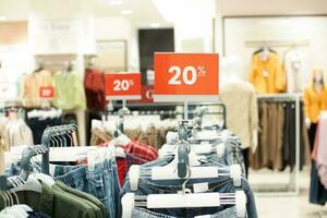 selectivo atención a rojo descuento tablero con 20 por ciento escribiendo. para descuento plantillas para De las mujeres y de los hombres ropa a el centro comercial. suave atención foto