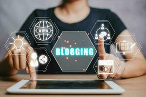 Blogging concept, Person using digital tablet on office desk with blogging icon on virtual screen. photo