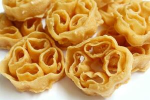 Kembang Goyang or shaking flower on white background, Indonesian typical homemade crispy fried snack in flowers shape. Traditional Indonesian Crackers photo