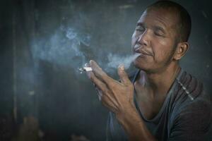 hombre fumando un cigarrillo. propagación del humo del cigarrillo. concepto para dejar de fumar foto