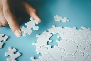 White jigsaw in the hands of humans, The correct solution. Teamwork, Solving and completing the task. Last piece of jigsaw puzzle. Assembling jigsaw puzzle pieces. photo