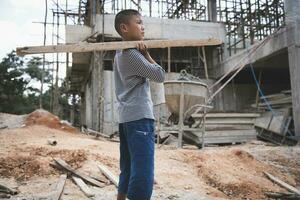 niños quien trabajo difícil en el construcción sitio, niño labor , mundo día en contra niño labor concepto. foto