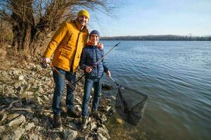 Father and son are ready for fishing on winter day. Freshwater fishing. photo