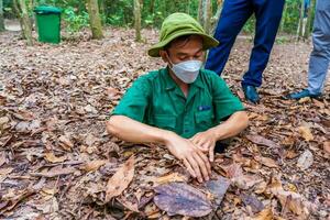 The Cu Chi tunnels. A guide demonstrating how a Vietcong hide into the Tunnel. It's used in Vietnam war. Famous tourist attraction in Vietnam. Stock photo