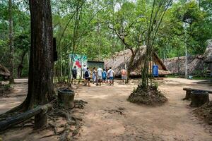 The Cu Chi tunnels. A guide demonstrating how a Vietcong hide into the Tunnel. It's used in Vietnam war. Famous tourist attraction in Vietnam. Stock photo