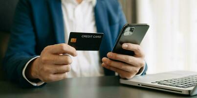 Man using smart phone for mobile payments online shopping,omni channel,sitting on table,virtual icons graphics interface screen photo