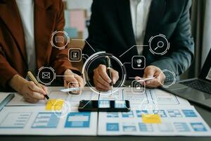 Close up view of UI developer team brainstorming on their project with laptop, smartphone and digital tablet. Creative digital development agency. with virtual icons photo