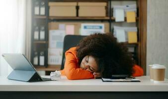 africano negocio mujer es estresado, aburrido, y pensando demasiado desde trabajando en un tableta a el oficina. foto