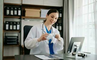 Attractive female doctor talking while explaining medical treatment to patient through a video call with laptop in office photo
