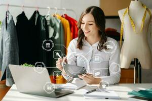 mujer mano utilizando un computadora portátil, teléfono inteligente y tableta y escritura cuaderno a el oficina de su negocio en línea compras. en hogar con virtual icono foto