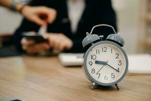 Alarm clock on the desk. Business working in modern office building or home at night using laptop. photo