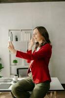 Working woman concept a female manager attending video conference and holding tablet, smatrphone and  cup of coffee in office photo