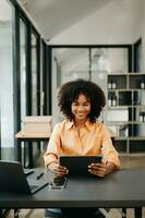 Business woman using tablet and laptop for doing math finance on an office desk, tax, report, accounting, statistics, and analytical research concept in office photo