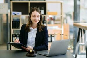 Beautiful woman lawyer working and gavel, tablet and laptop in front, Advice justice and law concept photo