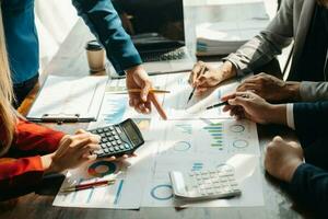 Business documents on office table with smart phone and calculator digital tablet and graph business with social network diagram and two colleagues discussing data working in the office photo
