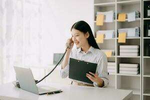 Happy asian business woman have the joy of talking on the smartphone, tablet and laptopon the  office photo