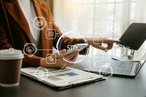 sdk software desarrollo equipo programación idioma tecnología concepto, persona mecanografía ordenador portátil computadora y tableta con sdk icono en virtual pantalla. foto