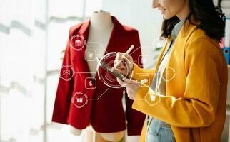 Woman hand using a laptop, smartphone and tablet and writing notebook at the home office of her business online shopping. In home with virtual icon photo