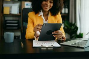 businesswoman working with digital tablet computer and smart phone with financial business strategy layer effect on desk in morning light photo