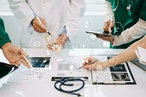 Medical technology network team meeting concept. Doctor hand working with smart phone modern digital tablet and laptop computer with graphics chart interface, with virtual icon photo