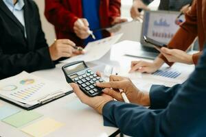 Businessman and team analyzing financial statement Finance task. with smart phone and laptop and  tablet. Wealth management concept photo