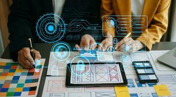 Close up view of UI developer team brainstorming on their project with laptop, smartphone and digital tablet. Creative digital development agency. with virtual icons photo