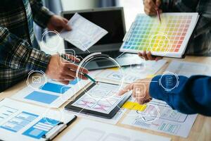 UX developer and ui designer brainstorming about mobile app interface wireframe design with customer breif and color code at office. with virtual icon photo
