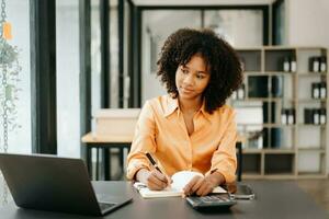 Business woman using tablet and laptop for doing math finance on an office desk, tax, report, accounting, statistics, and analytical research concept in office photo