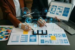 Close up view of UI developer team brainstorming on their project with laptop, smartphone and digital tablet. Creative digital development agency. with virtual icons photo