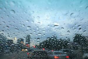 lluvia soltar en coche ventana con ciudad ver en el fondo, difuminar imagen foto