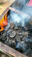 Charcoal made from coconut shells is being burned until smoke comes out photo