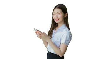 Portrait of an Asian Thai girl student in a uniform is smiling happily while using a smartphone at university isolated on white background. photo