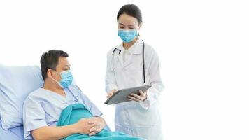 Professional young Asian woman doctor talking with a man patient who he is on bed about his pain and symptom in hospital. They wear a medical face mask to protect respiratory system. photo