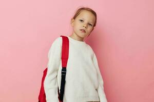 Portrait of happy smiling child girl with a red backpack fun isolated background photo