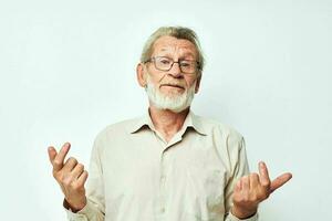 mayor canoso hombre con un gris barba en un camisa y lentes ligero antecedentes foto