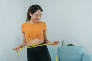 dieta y dieta. cinta métrica de uso de cuerpo femenino delgado de belleza. mujer con ropa de ejercicio logra el objetivo de pérdida de peso para una vida saludable, loca por la delgadez, cintura delgada, nutricionista. foto