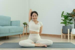 Slim woman practicing yoga on room of her condo or home. Asian woman doing exercises in morning. balance, meditation, relaxation, calm, good health, happy, relax, healthy lifestyle, diet, slim photo