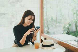 Asian working woman hold mobile phone text message, chat conversation or using social media. Businesswoman use smartphone browse web, read e-book, trade stocks. Communication technology concept. photo