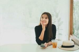 Asian working woman hold mobile phone text message, chat conversation or using social media. Businesswoman use smartphone browse web, read e-book, trade stocks. Communication technology concept. photo