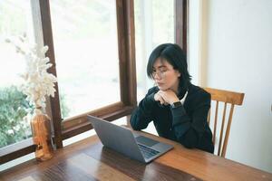 Business freelance entrepreneur woman with white headphone working typing keyboard on laptop and on wooden table at the cafe coffee shop. Business technology concept. photo