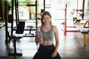 happy sport women exercise drink water workout smile training at the gym. athlete girl training strong and good health and strength. Fitness sport concept. photo