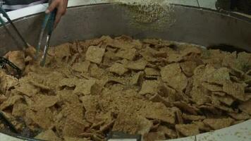 Close up of hands frying tempeh in a very large skillet video