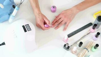 woman doing manicure with nail polish, Manicure at home for yourself. A woman's hand with healthy natural nails. video