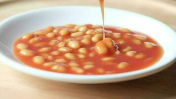 Tasty baked beans in a bowl on table video