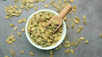 Pumpkin seeds in a small bowl on black background video