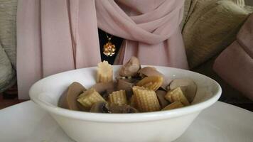 woman eating cooked mushroom on table video